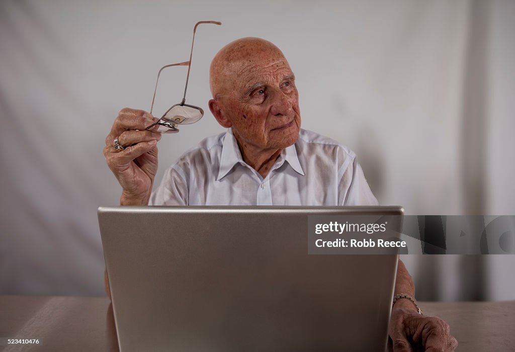 An elderly man using a laptop computer