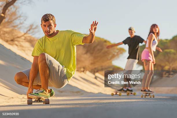 teenagers skateboarding on a road. - longboard skating stock pictures, royalty-free photos & images