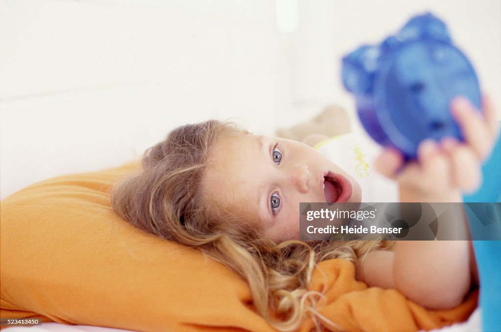 Girl Looking at Alarm Clock