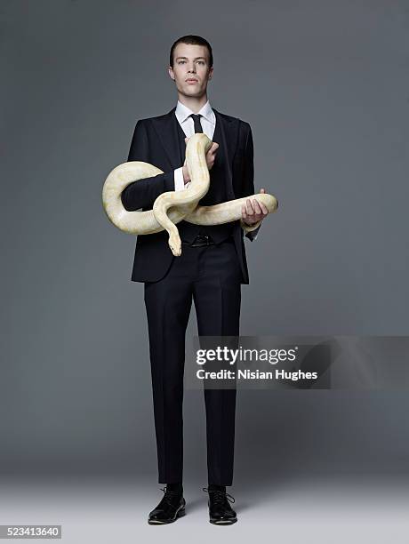 man in suit holding snake - python snake 個照片及圖片檔