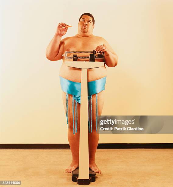 dieting sumo wrestler weighing himself - chubby foto e immagini stock