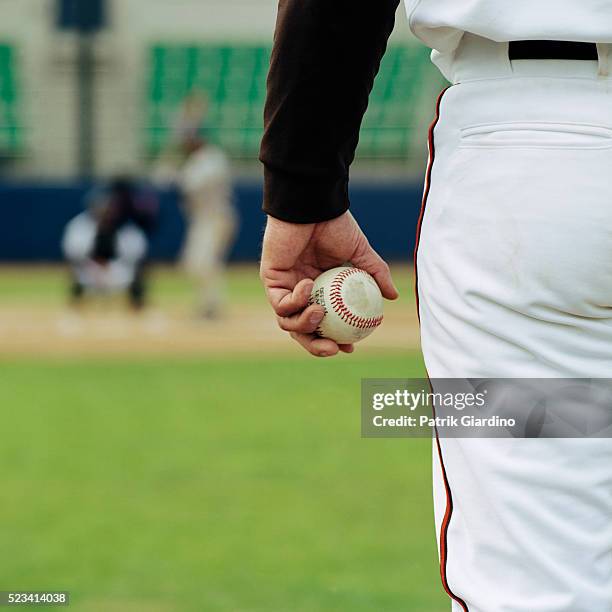 pitcher on mound holding baseball - baseball pitcher stock-fotos und bilder