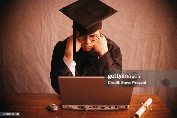 college graduate using laptop - arbeitslosigkeit stock-fotos und bilder