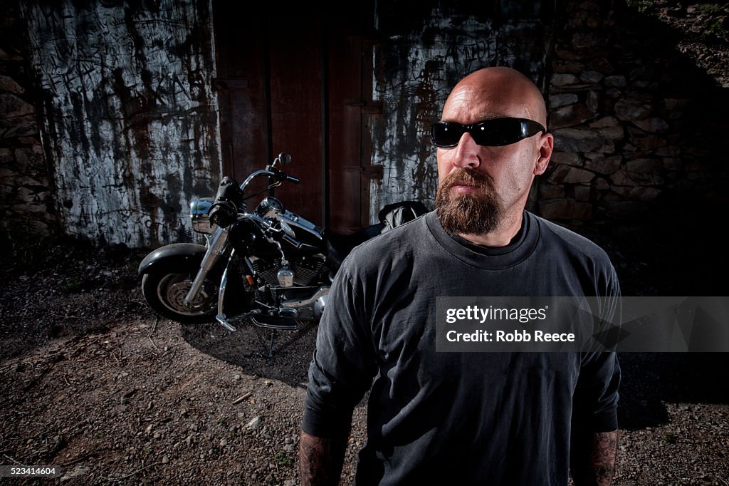 Bald man with his motorcycle behind