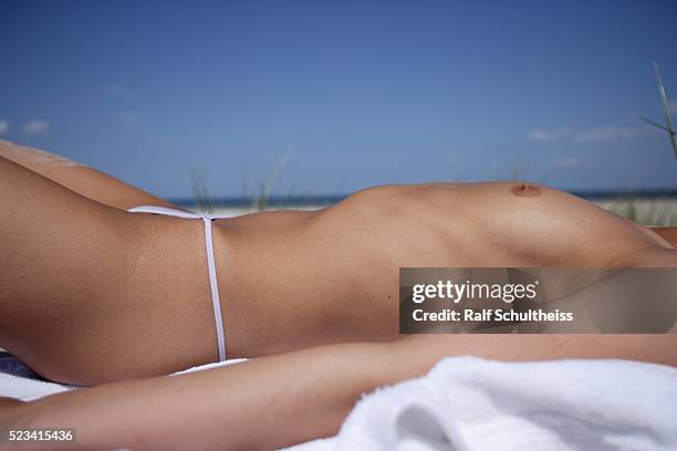 topless woman lying on the beach - semi dress stock pictures, royalty-free photos & images