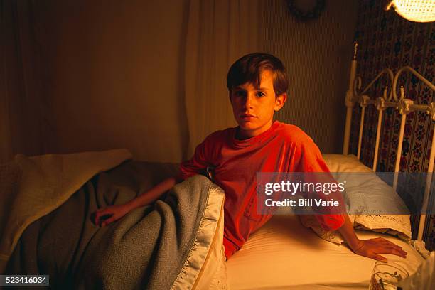boy sitting in bed - suspicion stock pictures, royalty-free photos & images