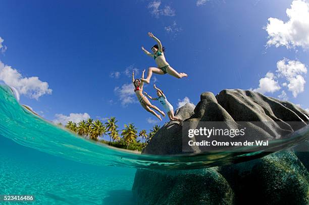 girls jumping off boulder in caribbean - caribbean 個照片及圖片檔