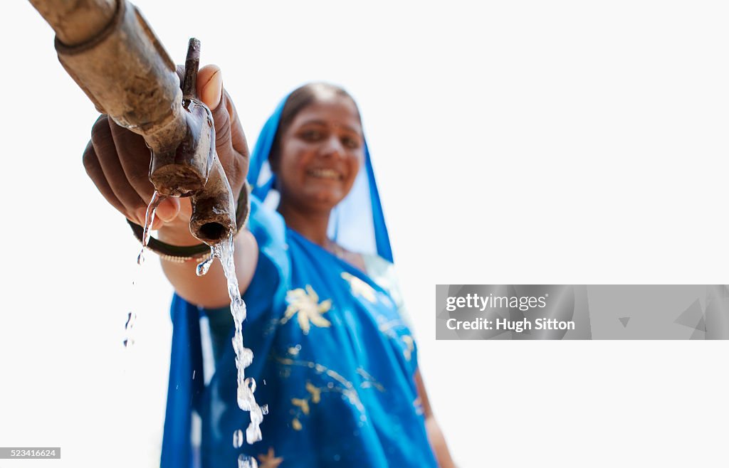 Hindu woman using faucet