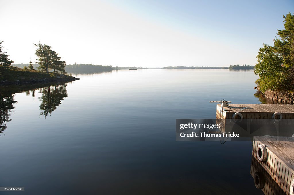 Cottage dock diving board on calm lake