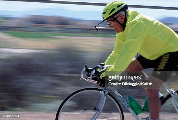 senior man bicycling - white spandex shorts stockfoto's en -beelden