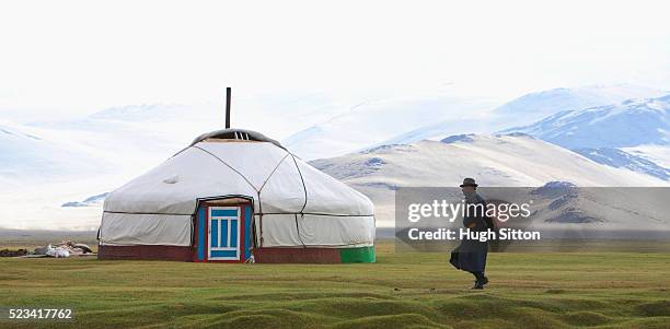 mongolian man walking towards a yurt - yurt stock pictures, royalty-free photos & images