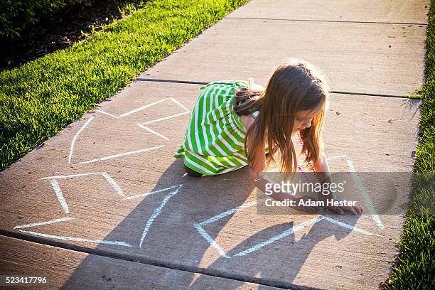 a young girl writing a recycling symbol on the sidewalk. - responsibility stock-fotos und bilder