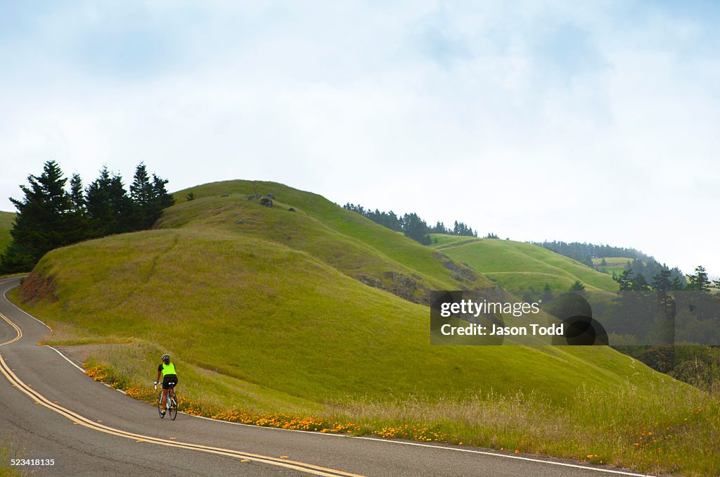 Woman riding along scenic highway among hills