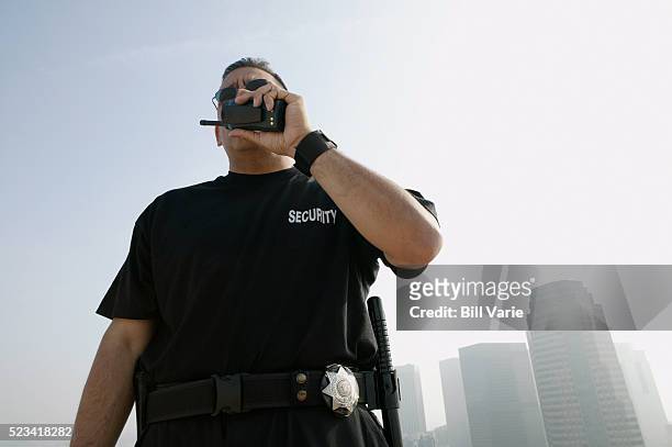 security guard talking on walkie-talkie - agent de sécurité photos et images de collection