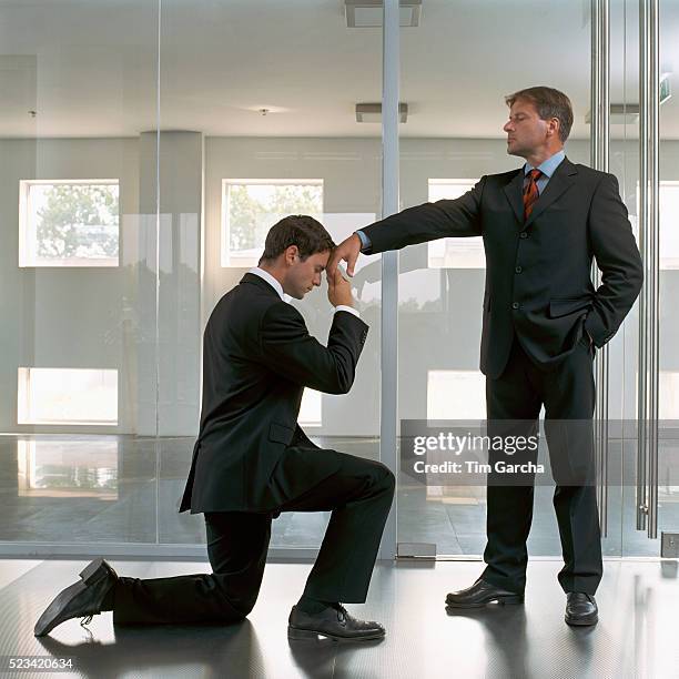 businessman kneeling to superior - agenouillé photos et images de collection