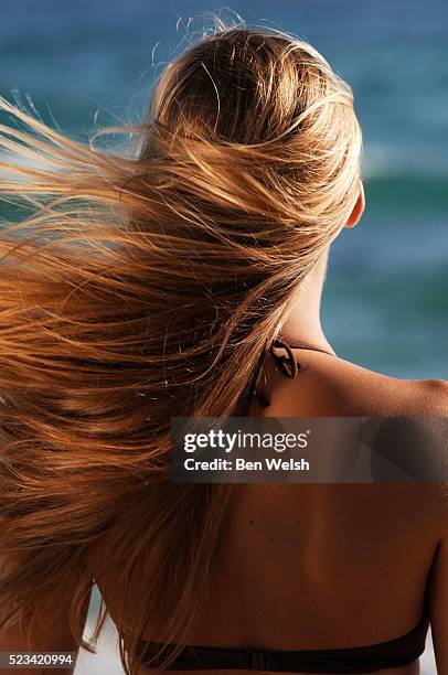 young woman with blond blowing hair - bräune stock-fotos und bilder