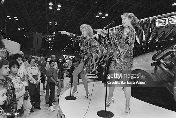 Two women sing to the audience on a stand for the new Chevrolet Beretta at the New York International Auto Show, Jacob Javits Convention Center, New...