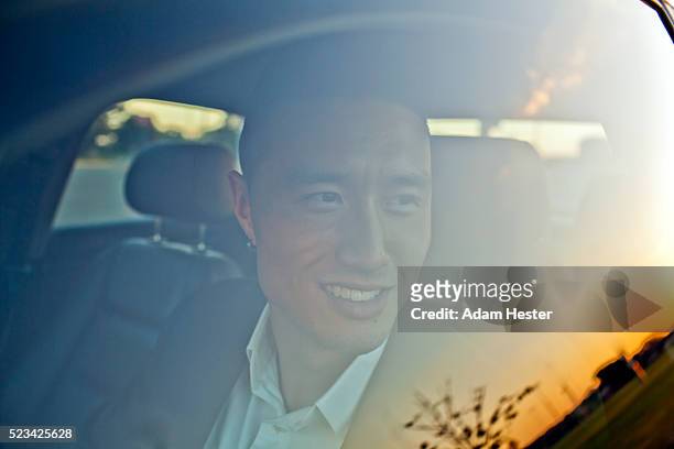 portrait of man behind car window - asian man car stock pictures, royalty-free photos & images