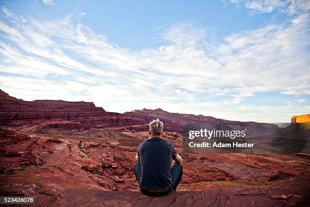 young man relaxing on desert, moab, utah, usa - hand on knee stock pictures, royalty-free photos & images