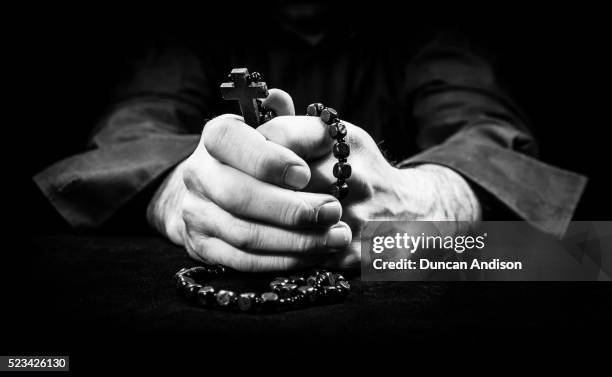 hands holding rosary beads and cross while praying - rosary beads stock pictures, royalty-free photos & images