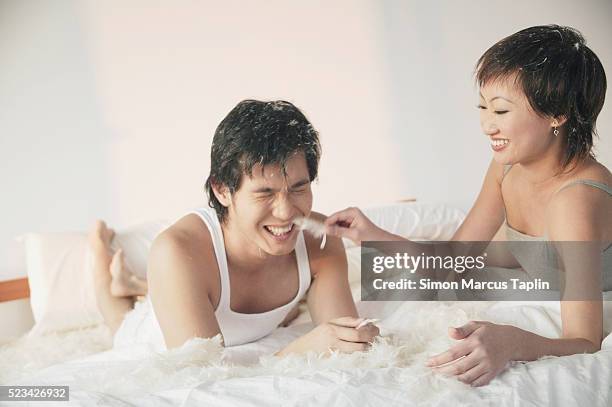 young couple goofing around in bed - tickling 個照片及圖片檔