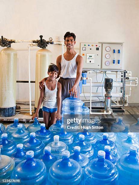 father and son in family run clean drinking water production plant - hugh sitton india stock pictures, royalty-free photos & images