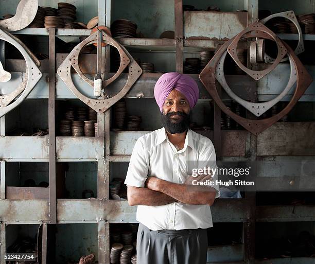 businessman standing in metal cutting shop - hugh sitton india fotografías e imágenes de stock