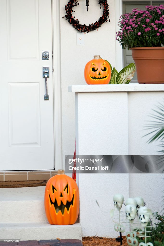 An array of different jack-o'-lantern decorations on a porch
