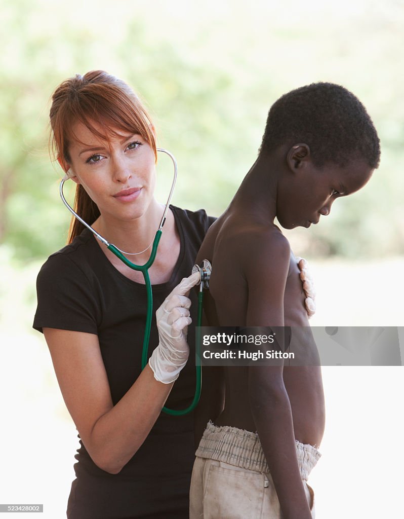 Doctor examining a young boy, Kenya