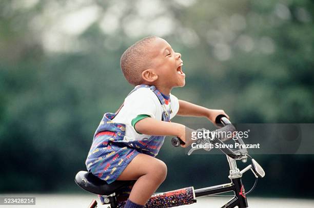 young boy learning to ride his bicycle - african american children playing fotografías e imágenes de stock