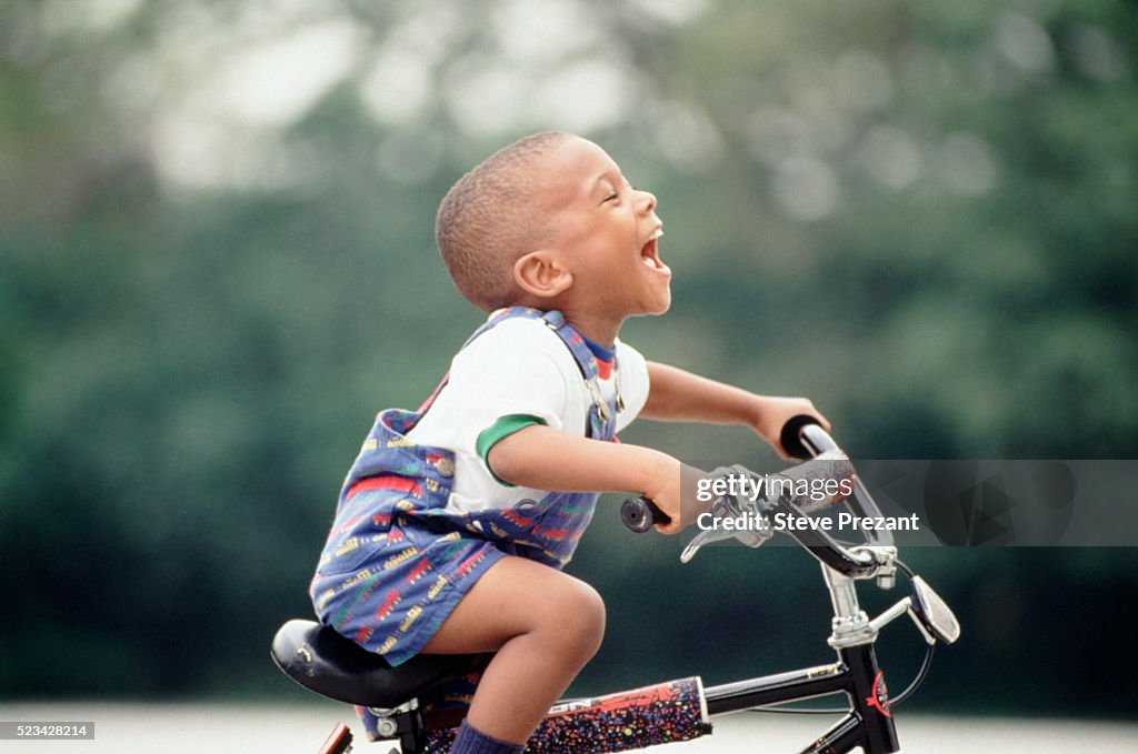 Young boy learning to ride his bicycle