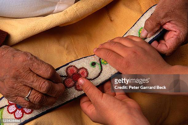 elderly ojibwa teaching traditions to child - bead stockfoto's en -beelden