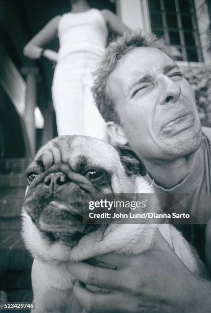 man holding pug and making face - ugly woman stockfoto's en -beelden