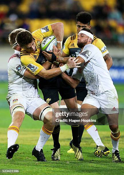 Beauden Barrett of the Hurricanes is tackled by Sam Cane and Aaron Cruden of the Chiefs during the round nine Super Rugby match between the...