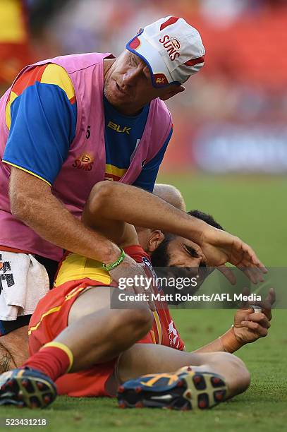 Adam Saad of the Suns receives attention on the field during the round five AFL match between the Gold Coast Suns and the North Melbourne Kangaroos...