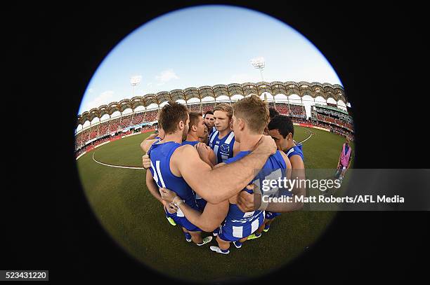 Players of the Kangaroos huddle before the round five AFL match between the Gold Coast Suns and the North Melbourne Kangaroos at Metricon Stadium on...