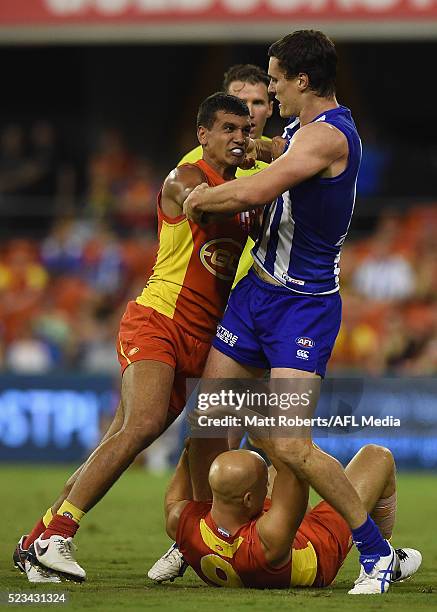 Callum Ah Chee of the Suns pushes Scott D. Thompson of the Kangaroos during the round five AFL match between the Gold Coast Suns and the North...