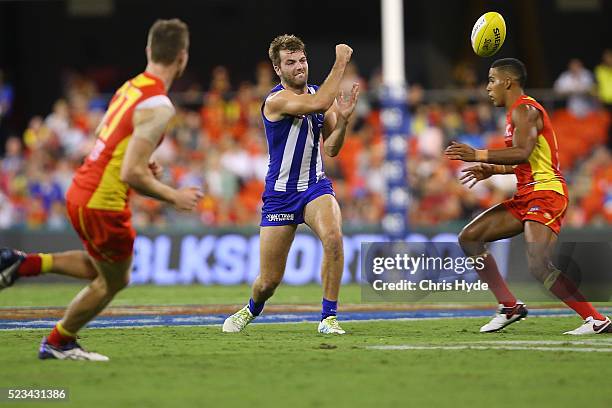 Luke McDonald of the Kangaroos handballs during the round five AFL match between the Gold Coast Suns and the North Melbourne Kangaroos at Metricon...