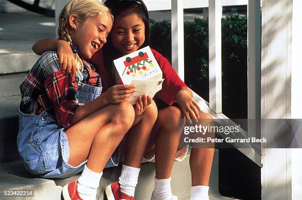 two friends reading a greeting card - sympathy card stock pictures, royalty-free photos & images