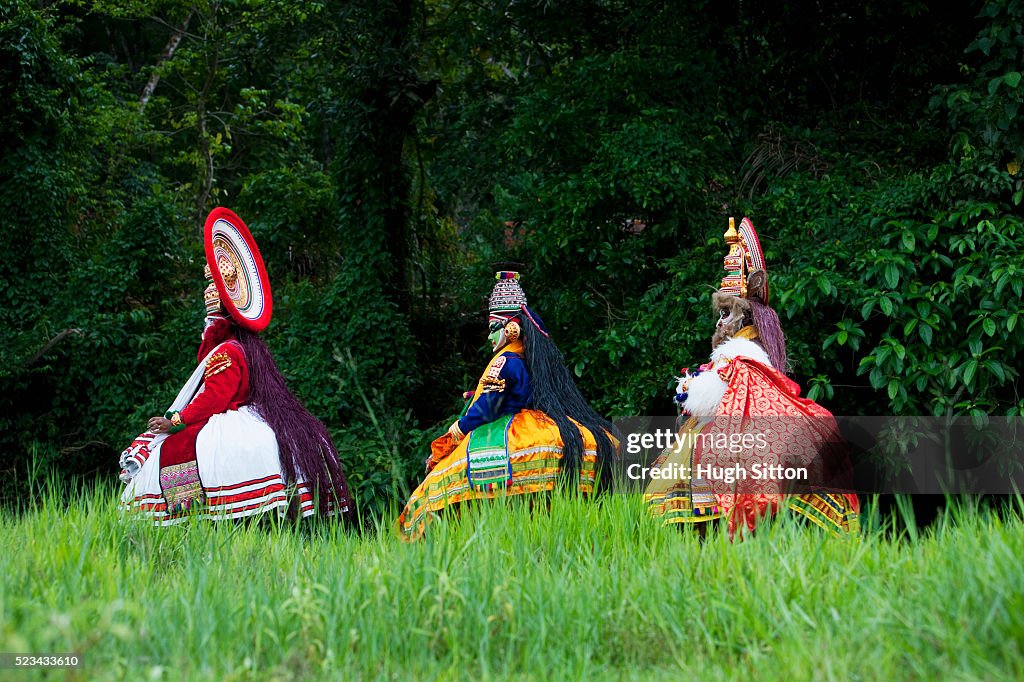 Three Kathakali dancers walking together, Southern India