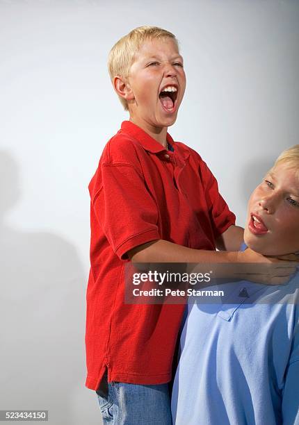 boy choking boy - bad brother stock pictures, royalty-free photos & images