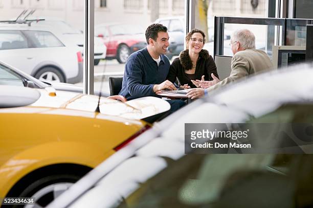 couple meeting with car salesman - venditore di automobili foto e immagini stock
