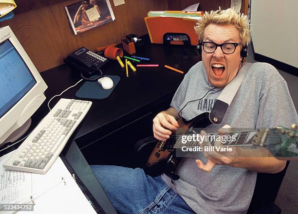 office worker playing guitar - elektrogitarre stock-fotos und bilder