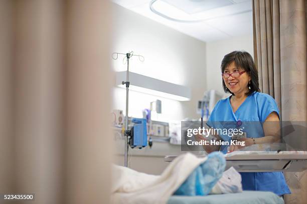 female nurse holding medication by hospital bed - preparing drug in hospital nurse stock pictures, royalty-free photos & images