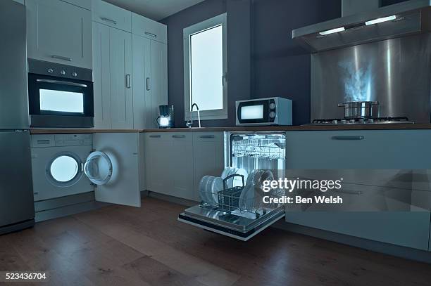 lights from appliances in dark kitchen - dark kitchen stock pictures, royalty-free photos & images