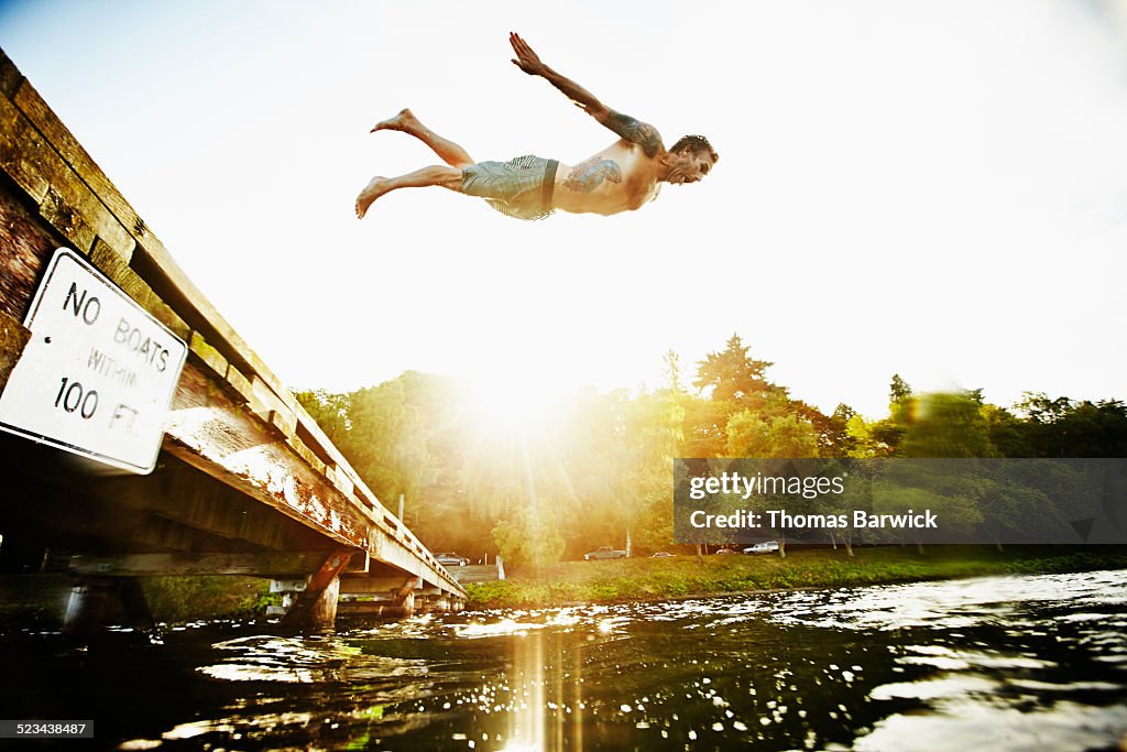 Man diving off of dock into lake