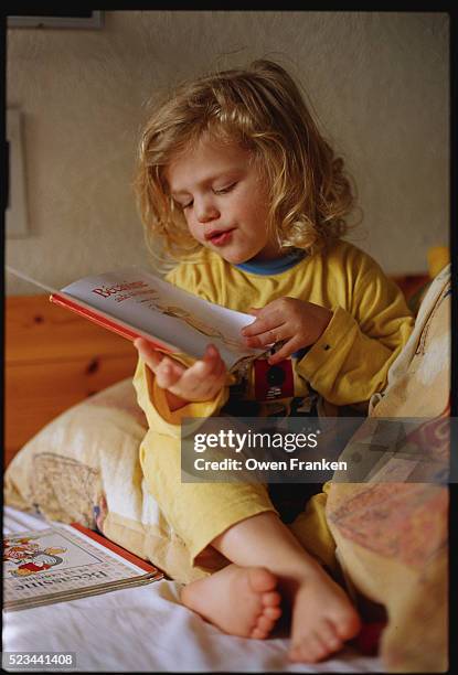 little girl reading - vêtement de nuit photos et images de collection