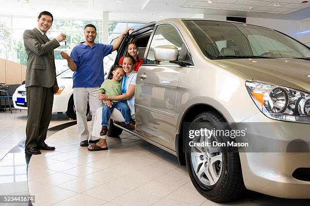 car salesman handing keys to family - new car stock pictures, royalty-free photos & images