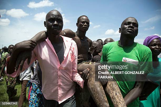 Wrestling supporters from Jonglei carry one of their wrestlers after being injured in a fight with an opponent from Terekeka in the final match of...