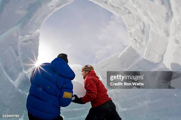 winter camping guide and camper building igloo - igloo stock pictures, royalty-free photos & images